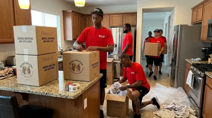 Midas Moving crew using cardboard boxes, packing tape, and packing paper to pack kitchen belongings in Gilbert, AZ