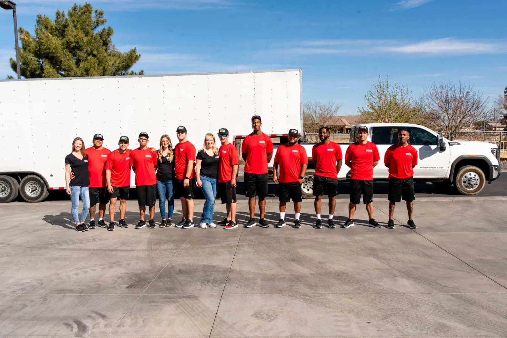 The Midas Moving team standing in front of their moving trucks