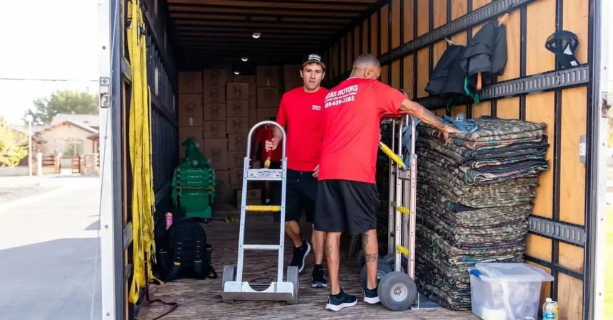 Midas Moving movers loading furniture and moving pads into a truck for a local move