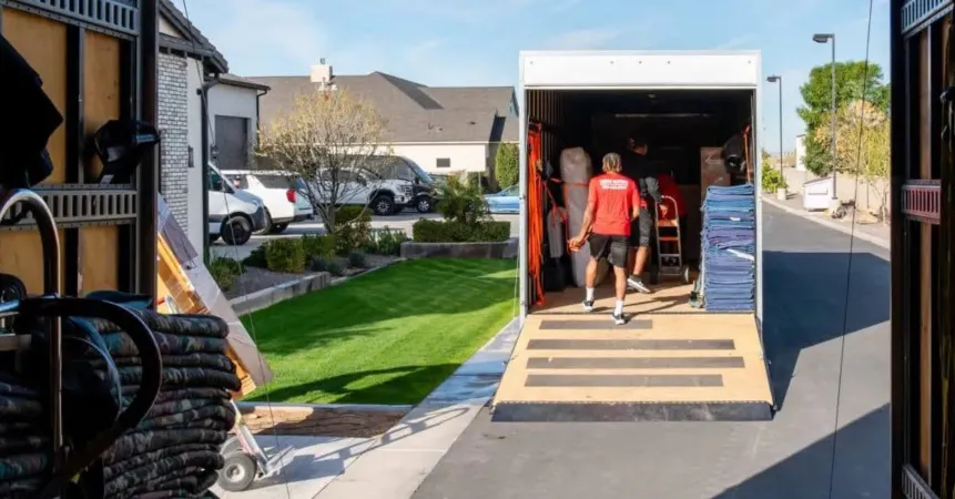 Midas Moving crew loading a moving truck using a ramp outside a home